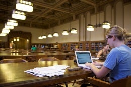 student with computer in library