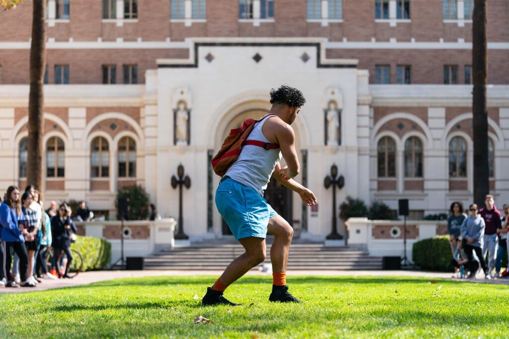 Chris Emile performing his piece in front of Doheny Memorial Library. Photo by Ling Luo.