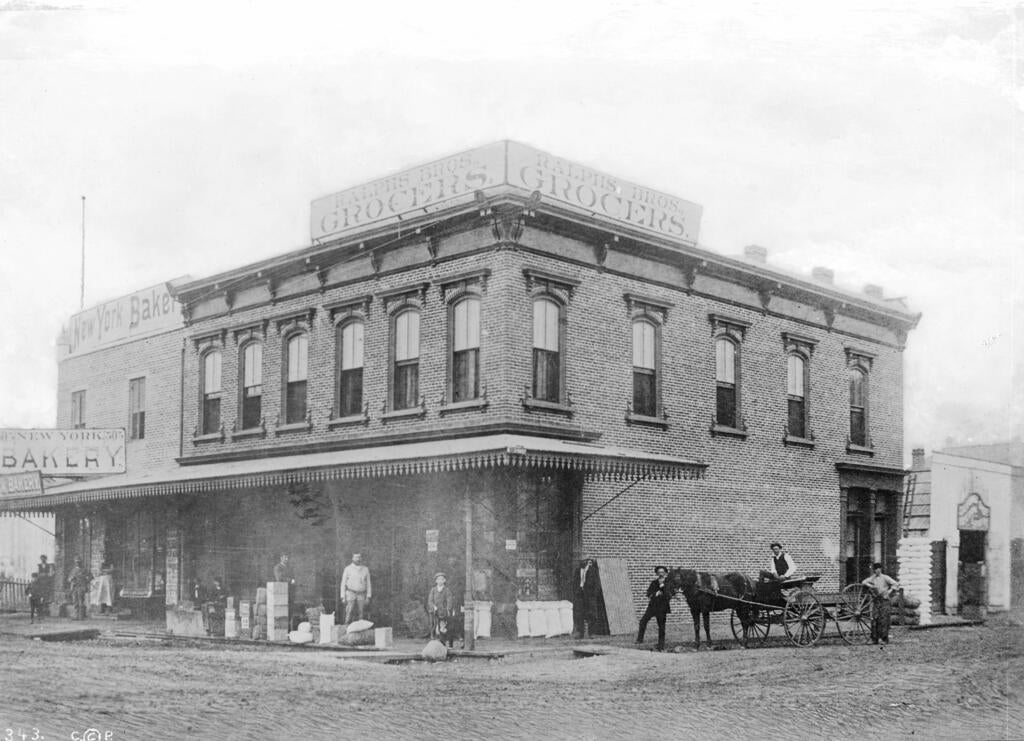 Exterior view of Ralphs Brothers Grocery and New York Bakery, located on the southwest corner of Sixth Street and Spring Street, 1886. Part of the California Historical Society Collection in the USC Digital Library.
